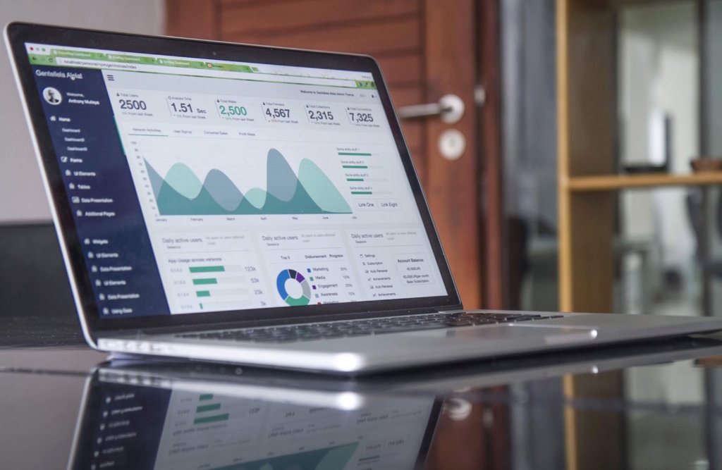 laptop on glass table with ecommerce traffic on screen